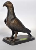A bronze effect cast metal statue of a pigeon, on a plinth base. 20cm tall