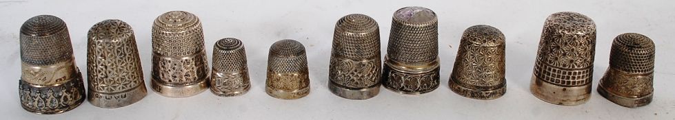A collection of six silver hallmarked thimbles each of Rococo design, along with others being