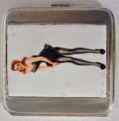 A white metal silver (stamped 925) and pictorial cigarette case with a lady fixing her stockings.