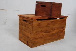 A modern contemporary pine blanket box having hinged lid with open interior. Together with a