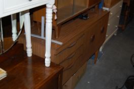 A faux teak wood danish style sideboard with drawers and cupboards being raised on tapered