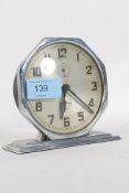 A 1930`s Art Deco chrome mantel alarm clock having decorative face being raised on a plinth base