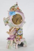 A continental porcelain timepiece clock with cherub and floral decoration having a French platform