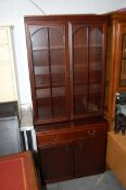 A Georgian style mahogany bookcase display cabinet. The top having glass doors with wooden shelves.