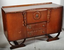 A 1930`s Art Deco oak sideboard. Raised on shaped supports having a central bank of drawers with