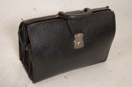 A vintage early 20th century leather briefcase having clasp and handle atop with lined interior