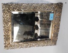 A vintage silver plate chase decorated framed mirror, with great detail to edging