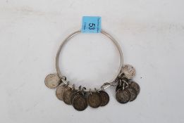 A silver threepence with names on reverse, all on a silver metal bangle