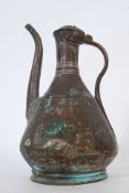 A 19th century copper and lead ewer of Asiatic formed with scrolled handle and lid