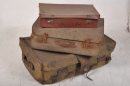 A stack of vintage suitcases to include, a good de-mob steamer trunk in green, of larger
