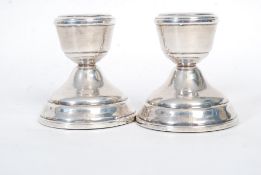 A pair of short hallmarked sterling silver candlesticks. Hallmarks to candle pot.