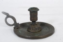 A 19th century bronze metal chamber stick candlestick holder with dolphin handle  chased and