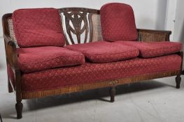 An Edwardian mahogany double cane bergere 3 seat sofa settee. Fleur de lys carved decoration to the