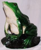 A 20th century hand painted and cast metal garden statue of a frog on a leaf.
