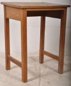 An early 20th century school desk of oak construction having open kneehole centre with solid top