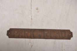 A vintage cast iron road sign for Park Road, with tapered edges and screw holes to corners.