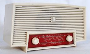 A vintage Ferranti bakelite radio in white, with twin knobs to front panel beneath Ferranti logo to