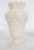 A Belleek Irish vase of decorative form being stamped to the underside. Together with a small