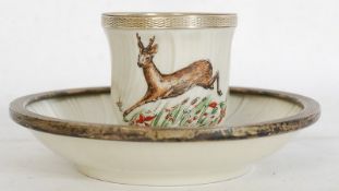 An early 20th century Bernardaut & Co Limoges beaker and saucer having decorative deer scene with