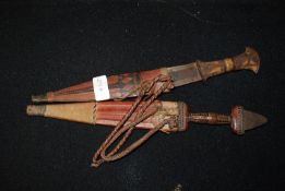 2 Indian Kukrie knives / daggers in leather scabbards together with a further indian dagger in