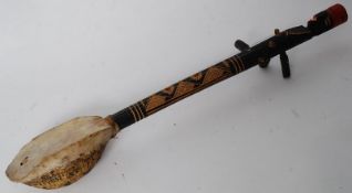 An antique tribal style instrument with tortoiseshell base and carved wood neck.