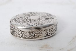 A white metal silver (tested) rococo scroll and foliate decorated snuff / pill box.