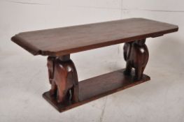 An Africal tribal hardwood coffee table, the rectangular body having animal carved uprights. 40cm