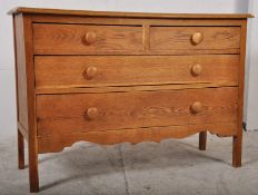 A 1920's solid oak cottage chest of drawers. Raised on square supports having 2 short drawers over 2