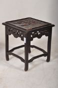 A 20th century carved hardwood Chinese oriental stool, with carved scene to top. 33cm tall.