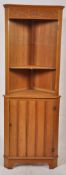 A light wood 20th century oak corner cabinet having cupboard to the base with open shelf atop. H182