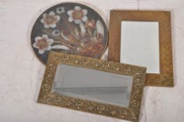 Two brass framed bevelled edge mirrors along with a wall hanging collage made from bird feathers.