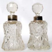 A pair of hallmarked silver rimmed miniature cut glass decanters, with glass multi-faceted