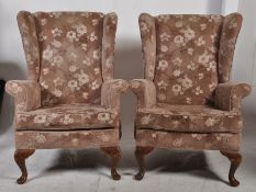 A pair of mid 20th century wingback armchairs. Raised on mahogany cabriole legs with velour