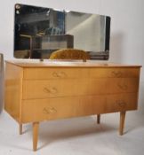 A 1970's teak veneer light wood dressing table chest of drawers. Raised on tapered legs with a