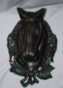 A large hand painted cast metal wall hanging horse head, with moving ring to nose - possibly a