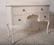 A 1930's painted shabby chic Queen Anne revival dressing table / desk being raised on cabriole