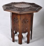 A 20th century carved wood games table, profusely carved top with carved raised scalloped bowl to