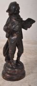 A 19th century Victorian continental bronze figure of a young scholar reading a book being raised on