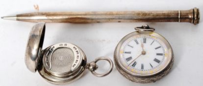 A silver enamel faced pocket watch along with a hallmarked silver sovereign holder and a Sharpes