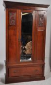 An Edwardian walnut carved panel single wardrobe with flared cornice and a single drawer to the