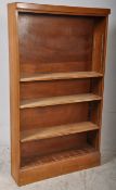 A 1940's walnut open window tall bookcase cabinet. The plinth base supporting an upright body with