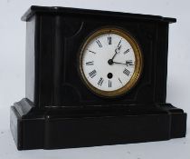 A Victorian slate mantel clock. The enamel face set with roman numerals,all within a slate case