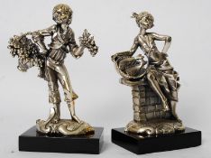 A pair of 800 stamped silver plate figurines of a buy and a girl raised on ebonised plinths (