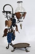 An unusual large wine dispenser. Of wroght metal construction with applied grape vines having