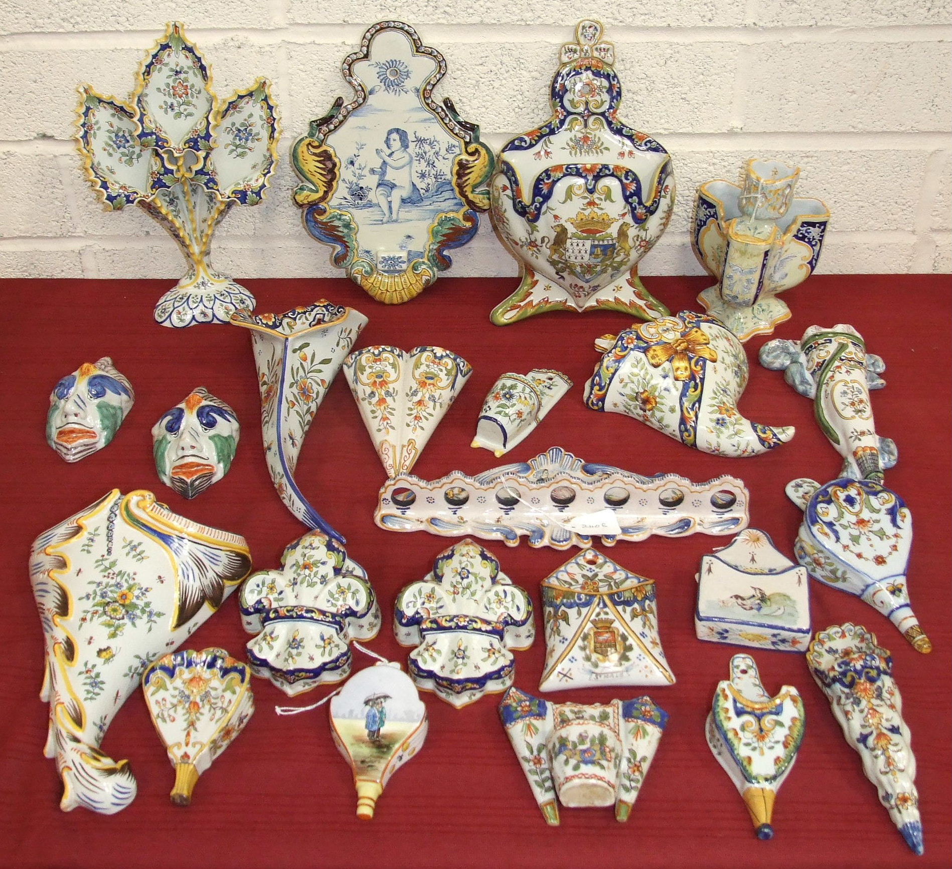 A collection of thirty-two French Faience wall pockets, plaques, fan-shaped flower holders and a