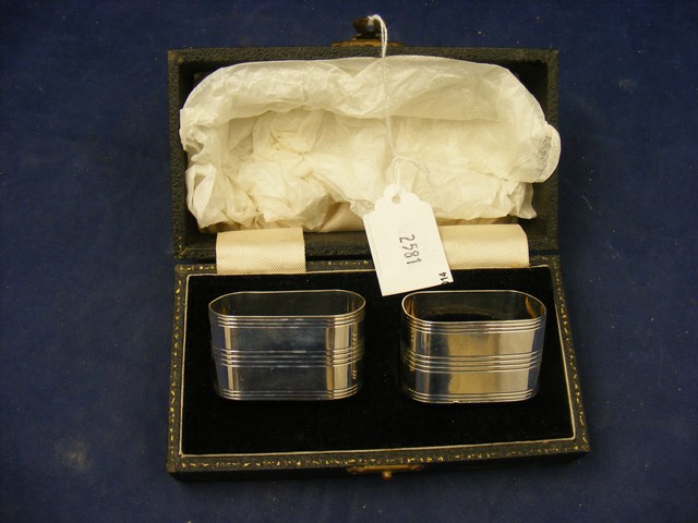 A pair of silver napkin rings in case