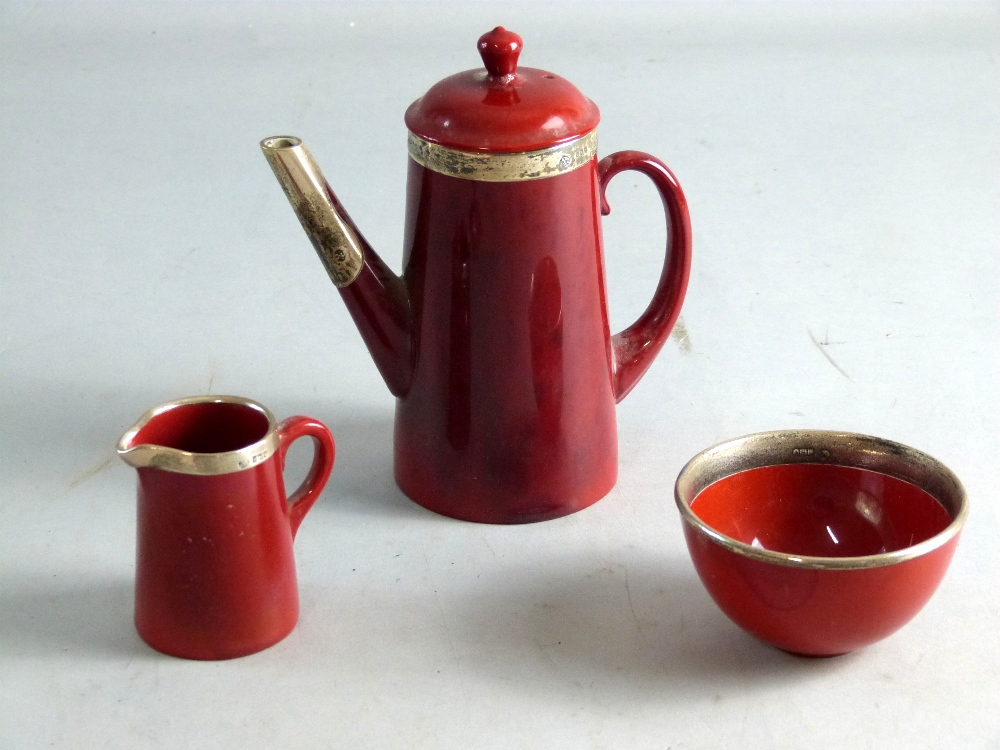Doulton flambe glaze silver mounted coffee pot, cream jug and sugar bowl, Hall mark on coffee pot