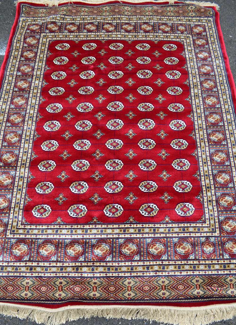 Red ground Kashmir rug with a Bokhara design, 200cm x 140cm