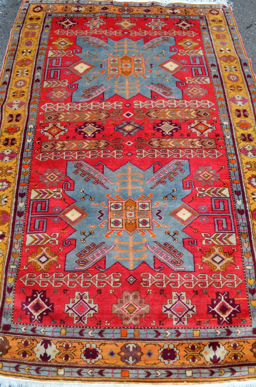 Persian red ground carpet, main yellow border the centre decorated with a pair of shaped blue