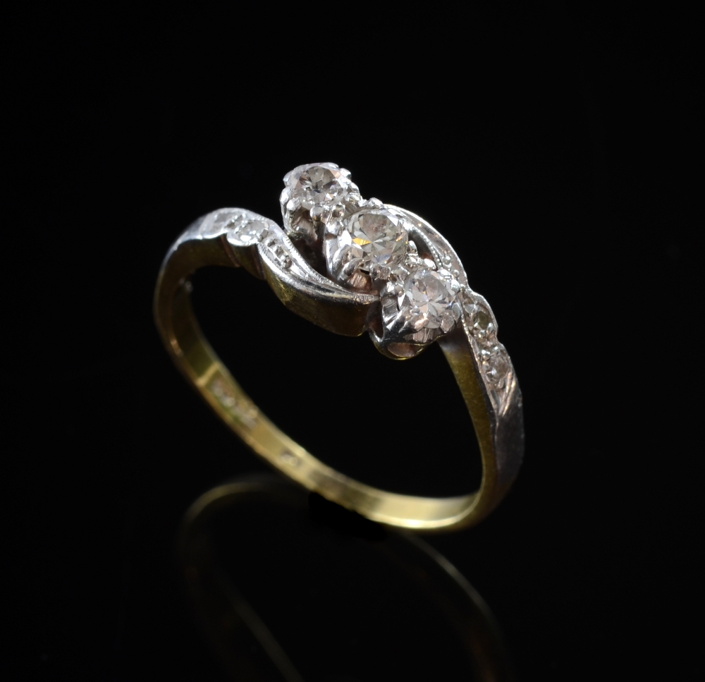 Edwardian diamond three stone crossover ring set in white and yellow goldOverall in good condition